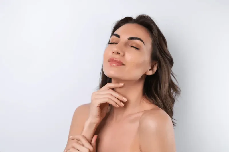 The image depicts a woman with radiant, glowing skin, eyes closed, highlighting the benefits of using a face wash to maintain a clear and healthy complexion.